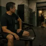 Hombre mexicano de cuarenta y cinco años mira a un joven tatuado al cierre de un gimnasio de barrio en Ciudad de México.
