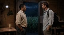 Hombre zapoteco y visitante español se miran dentro de una cabaña junto a una milpa de la Sierra Norte de Oaxaca.