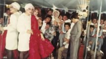 Grupo de personas con atuendos de fiesta y vestuario escénico frente a espejos en una fotografía de época.